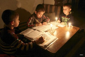 Палестинские мальчики делают уроки при свечах в отсутствии иного источника света 