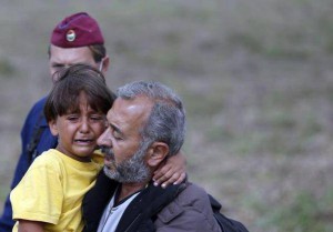 Осама Мохсен держит на руках плачущего сына 